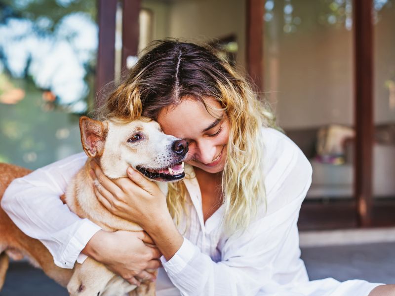 Woman hugging her happy dog.