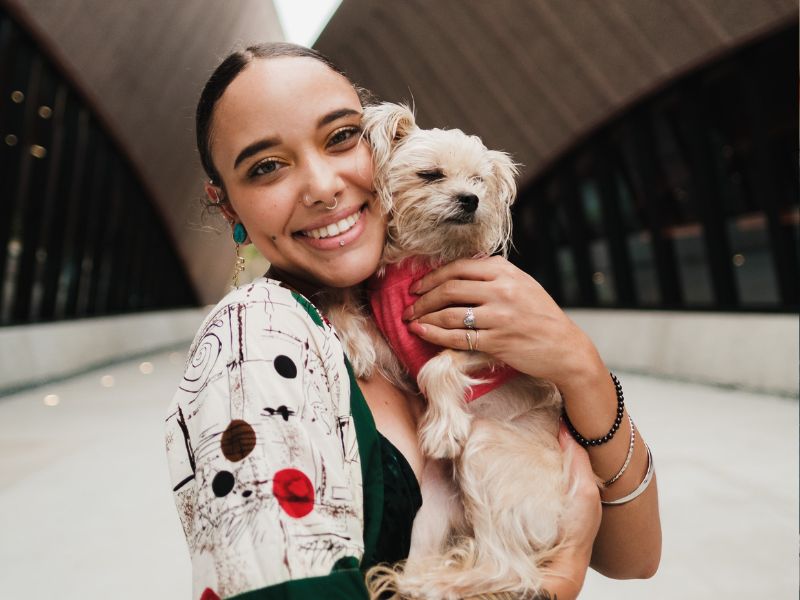Woman smiling, holding dog